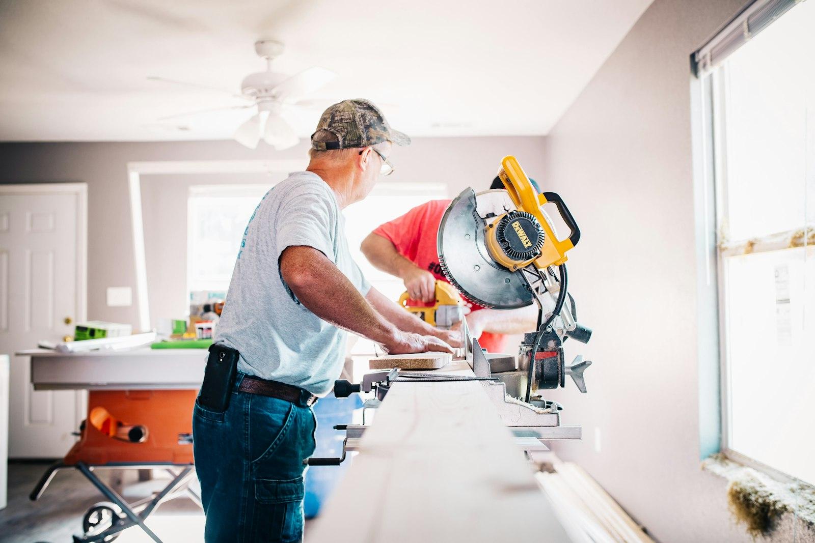 Een vakman zaagt een plank op maat bij een verbouwing in huis