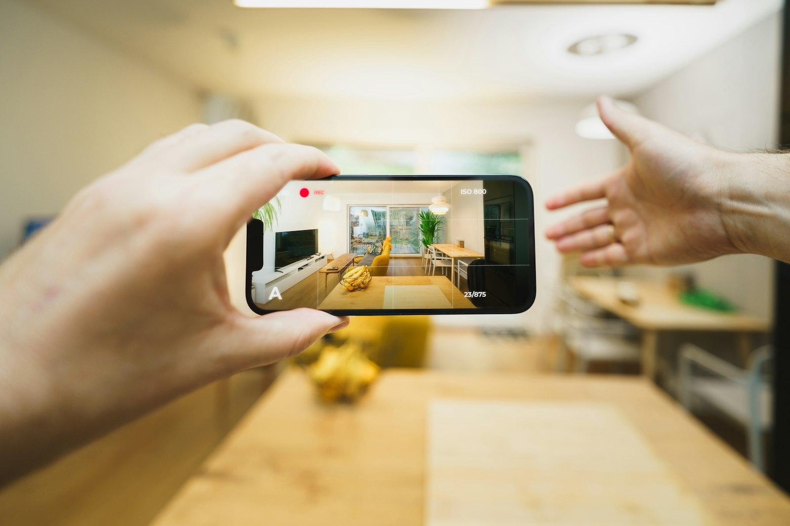 Iemand fotografeert een keuken met een telefoon tijdens een bezichtiging